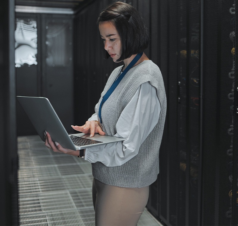 A healthcare IT technician works on a computer in a medical office, managing electronic health records and ensuring technology systems run smoothly to support patient care.